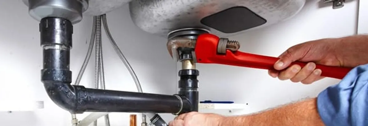 Garbage disposal repair technician tightening the sink drain and disposal connection in Clearwater, FL