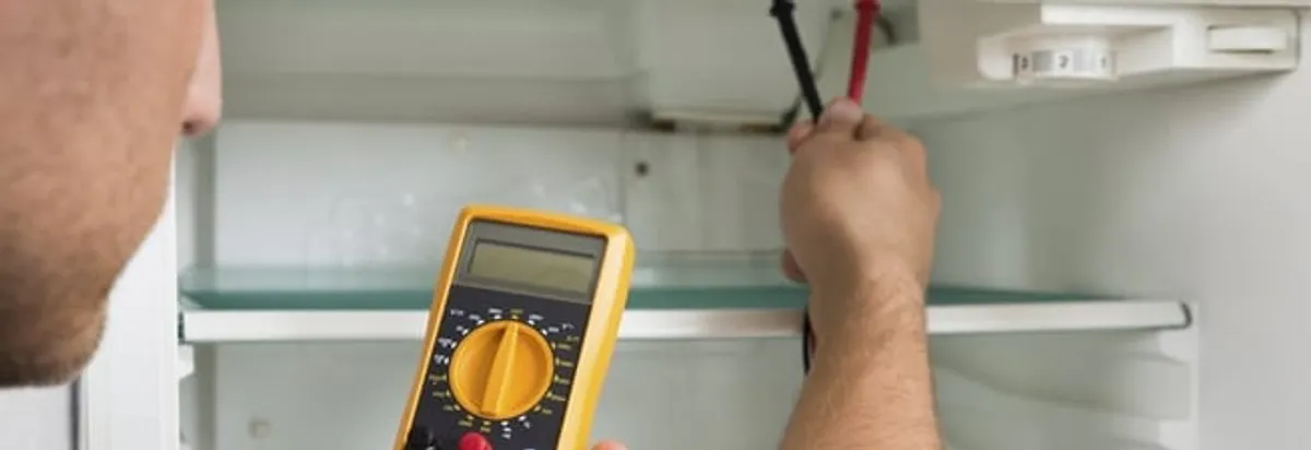 Refrigerator repair technician testing electrical components with a multimeter in Clearwater, FL